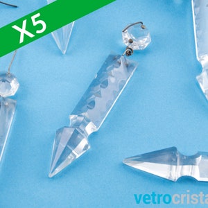 May include: Five clear glass crystal teardrop-shaped pendants with a faceted design. The pendants have a pointed tip and a small, round bead at the top. The pendants are hanging on a blue background.