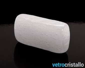 May include: A white, opaque, rectangular block of glass with a textured surface. The glass block is smooth and has a slightly rounded edge.