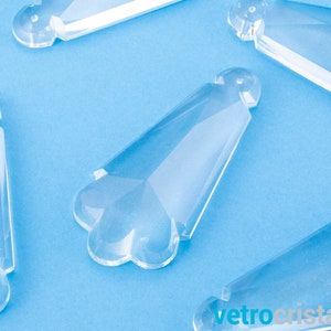 May include: Clear glass crystal prisms with a faceted design. The prisms are shaped like a teardrop with a pointed tip and a rounded base.