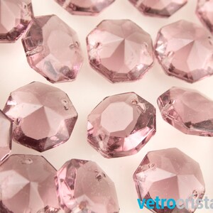 May include: A scattering of small, faceted, octagonal, light pink glass beads. The beads are translucent and have a slight shimmer.