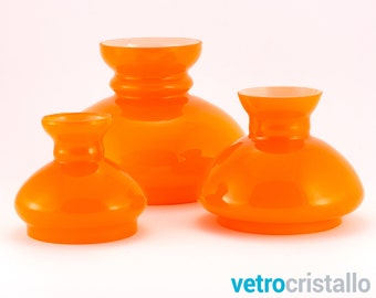 May include: Three orange glass lampshades of varying sizes. The lampshades are round and have a wide, flared base.