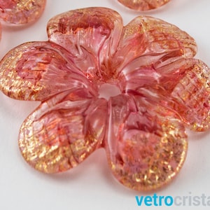 Op de afbeelding: Een roze glazen bloem met gouden vlekken. De bloem heeft vijf bloemblaadjes en een gat in het midden.