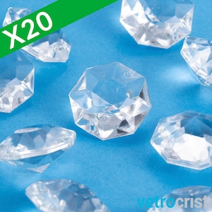 May include: Twenty clear glass diamond-shaped embellishments on a blue background.  X20.