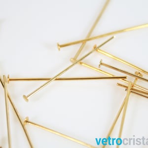 Op de afbeelding: Een stapel gouden kopspelden, gebruikt voor het maken van sieraden en knutselen.