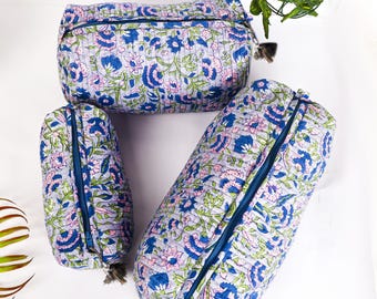 Puede incluir: Tres neceseres acolchados de diferentes tamaños. Presentan un estampado floral en azul, rosa y verde sobre un fondo lila claro. Cada neceser tiene una cremallera azul y una borla. Los neceseres están dispuestos sobre una superficie blanca.