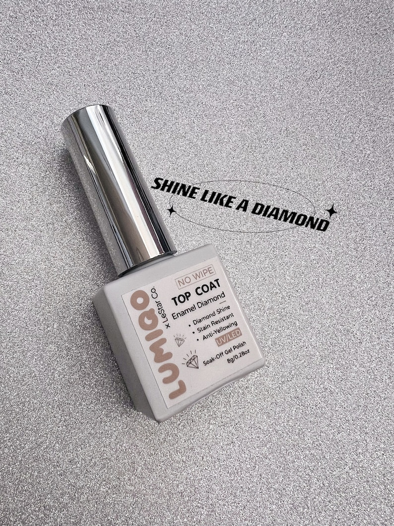 May include: A clear bottle of Lumigo &times; LeStar Co. No Wipe Top Coat Enamel Diamond soak-off gel polish. The bottle is labeled with the text "Shine Like a Diamond" and features a diamond icon. The bottle is 0.28 oz (8g).