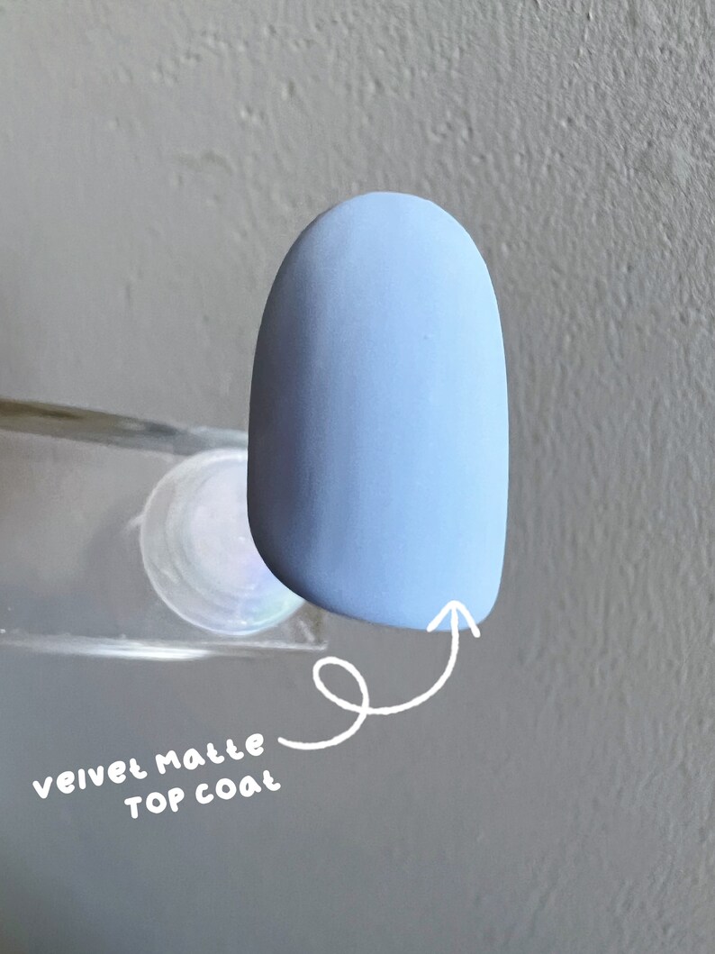 May include: A light blue nail polish with a matte finish. The text "velvet matte top coat" is written on the image.