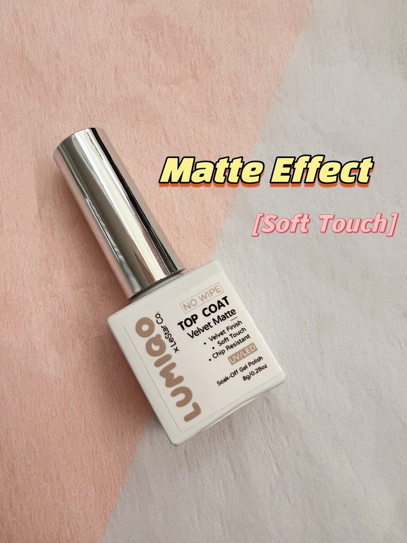 May include: A white bottle of LUMIGO &times; LeStar Co. NO WIPE TOP COAT Velvet Matte soak-off gel polish. The bottle is labeled with the product name, brand, and size: 8g/0.28oz. The bottle is on a light pink and white surface.