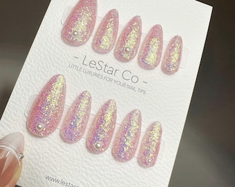 Handgemaakte roze kosmische glitterpers op nagels met parelaccent