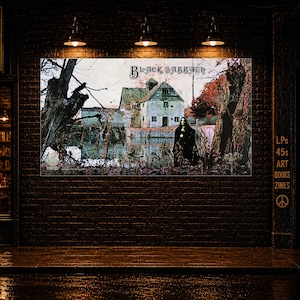 May include: A rectangular wall poster featuring the Black Sabbath album cover art, depicting a dark, moody landscape with a stone mill, a pond, and a cloaked figure standing among trees, displayed on a dark brick exterior wall of a shop.