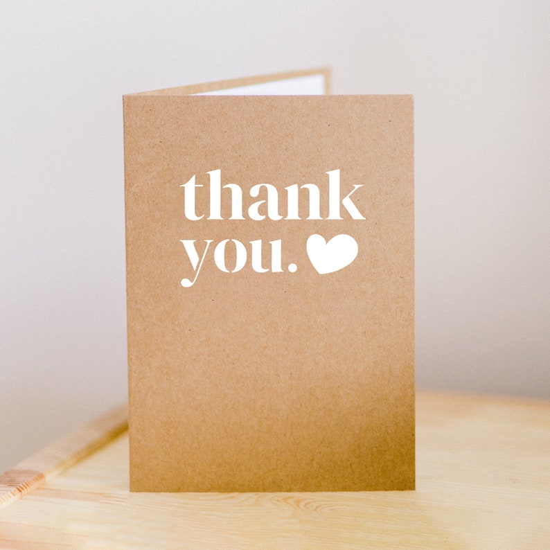 May include: A brown card with the text "thank you." in white with a white heart next to the period.