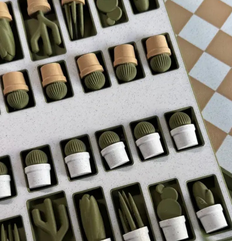 Puede incluir: Un tablero de juego blanco con piezas de juego verdes en forma de cactus. El tablero tiene un patr&oacute;n de cuadr&iacute;cula y est&aacute; dividido en cuadrados. Las piezas de juego est&aacute;n dispuestas en filas y columnas en el tablero.