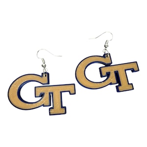 May include: A pair of gold and blue earrings with the letters "GT" on them.