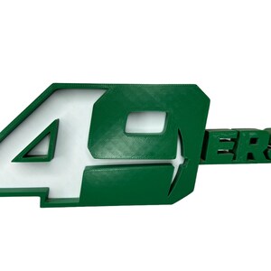 May include: Green 3D plastic 49ers logo with white lettering.