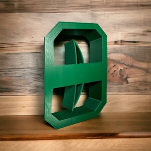 May include: A green plastic mold for making concrete stepping stones. The mold is shaped like a rectangle with rounded corners and has a design of two overlapping circles.
