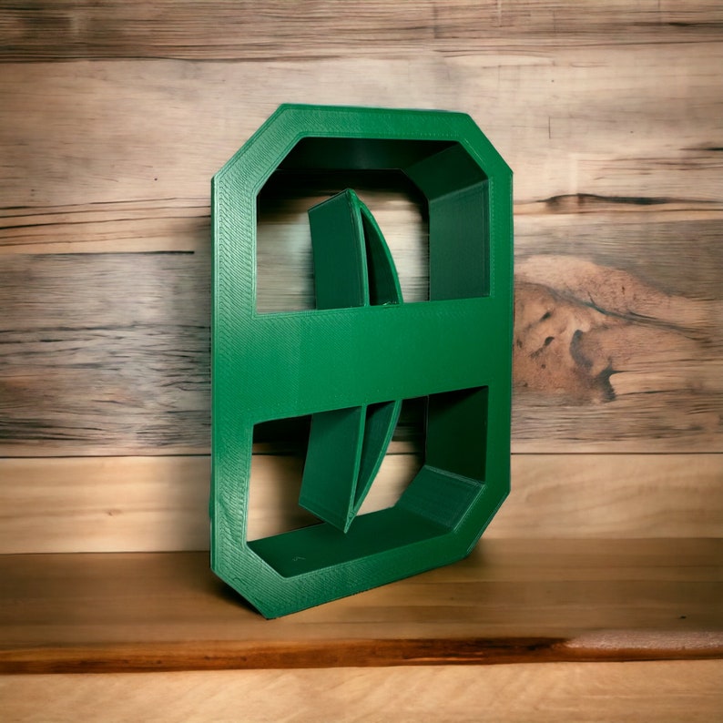 May include: A green plastic mold for making concrete stepping stones. The mold is shaped like a rectangle with rounded corners and has a design of two overlapping circles.