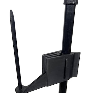 May include: A black plastic flag holder with a pointed tip and a clamp that attaches to a pole.