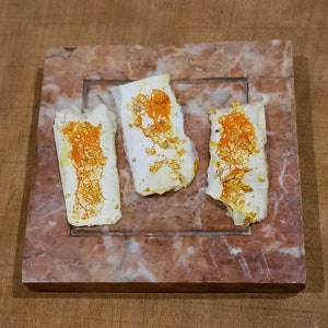 Peut inclure: Trois morceaux de papier blanc avec des taches orange et jaunes sur une surface en marbre.