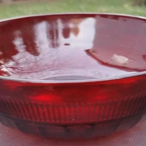 Könnte beinhalten: Eine weiße Keramik-Tasse mit schwarzem Henkel und dem Text "But First, Coffee" in schwarzer, handschriftlicher Schrift. Die Tasse steht auf einer weißen Oberfläche.