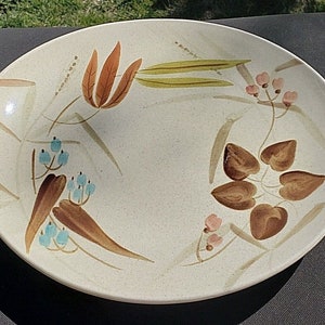 May include: A white ceramic oval serving dish with a brown, green, and pink floral design. The design features stylized leaves and flowers with brown stems.