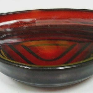 May include: A decorative, triangular-shaped bowl with a glossy finish. The bowl features a vibrant red interior with black accent lines and a dark brown exterior. The bowl's design is reminiscent of mid-century modern art.