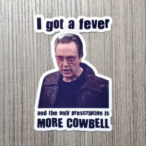 May include: A sticker featuring a man with a serious expression wearing sunglasses and a leather jacket. The text on the sticker reads "I got a fever and the only prescription is MORE COWBELL."