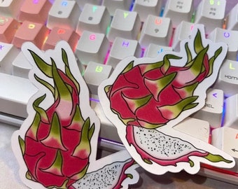 Könnte beinhalten: Zwei Aufkleber mit einer Drachenfrucht, eine ganz und eine aufgeschnitten, auf weißem Hintergrund. Die Frucht ist rosa mit grünen Blättern und weißem Fruchtfleisch.