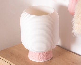 May include: White ceramic lamp with a pink fuzzy base, sitting on a wooden nightstand with a drawer.