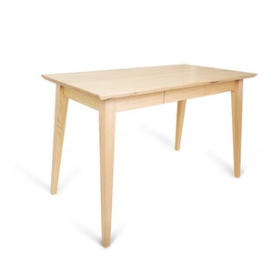 May include: A light wood desk with a drawer and tapered legs. The desk is made of solid wood and has a natural finish.