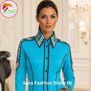 May include: A bright turquoise long-sleeve button-down shirt featuring black piping and intricate geometric crystal embellishments on the collar, shoulders, and cuffs. The shirt displays the text Sara Fashion Store IN and is paired with a black belt.