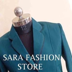 May include: A teal blazer with black trim and three buttons. The blazer is on a mannequin and has the text "SARA FASHION STORE" on the front.