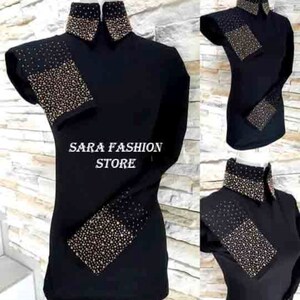 May include: Black long-sleeve shirt with gold rhinestone embellishments on the collar, cuffs, and shoulders. The shirt has a high collar and a fitted silhouette. The text "SARA FASHION STORE" is visible on the shirt.