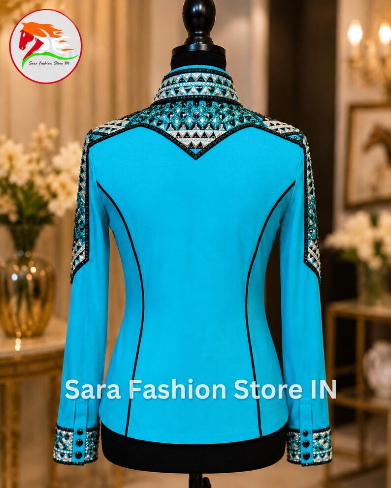 May include: A bright turquoise long-sleeve shirt featuring a high collar, black piping accents, and intricate geometric crystal embellishments across the shoulders, collar, and cuffs. The text Sara Fashion Store IN is printed at the bottom.