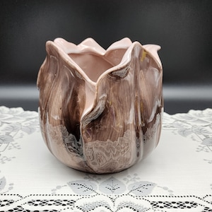 May include: A brown ceramic flower pot shaped like a tulip with a glossy finish.