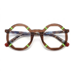 Puede incluir: Gafas octogonales con montura marrón translúcida y detalles en verde lima brillante en las esquinas. El interior de las patillas muestra un diseño estampado en azul y marrón, y los cristales transparentes se sujetan en la estructura geométrica.