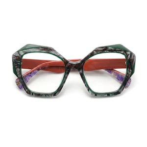Puede incluir: Gafas geométricas con una montura multicolor que presenta un patrón jaspeado en verde oscuro y gris en la parte frontal. Las varillas interiores son de un color naranja terracota sólido, mientras que los terminales muestran un diseño jaspeado.