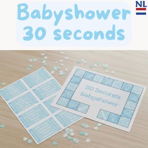 Könnte beinhalten: Zwei Babyparty-Spielkarten mit dem Text "Babyshower 30 seconds" in Hellblau. Eine Karte ist ein Spielbrett, die andere hat mehrere Etiketten. Verstreute Konfetti in Form von Herzen und Schleifen liegen auf der Holzoberfläche.