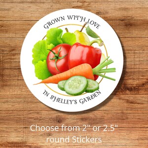 Op de afbeelding: Ronde sticker met een witte achtergrond en een gouden rand. De sticker heeft een kleurrijke illustratie van verse producten, waaronder een tomaat, paprika, wortel, komkommer, peer en groene bladeren. De tekst "GROWN WITH LOVE IN SHELLEY'S GARDEN" is in zwart op de sticker gedrukt.