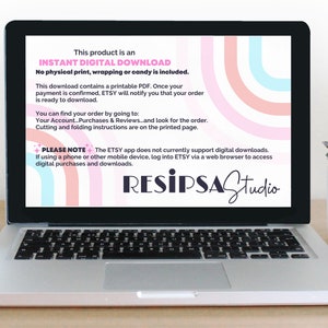 May include: A laptop screen displaying a pink, blue, and white graphic design with the text "This product is an INSTANT DIGITAL DOWNLOAD. No physical print, wrapping or candy is included." and "PLEASE NOTE+ The ETSY app does not currently support digital downloads. If using a phone or other mobile device, log into ETSY via a web browser to access digital purchases and downloads." The text "RESIPSAStudio" is in black and white.