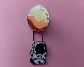 Enamel pin Astronaut hanging on a planet