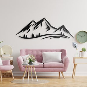 May include: Black metal wall art depicting a mountain range with trees in front of the mountains. The art is hanging on a white wall in a living room setting with a pink sofa, a side table, and a floor lamp.