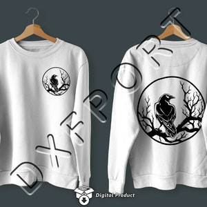 Puede incluir: Sudadera blanca con un dise&ntilde;o de silueta de cuervo negro en la espalda. El cuervo est&aacute; posado en una rama dentro de un c&iacute;rculo.