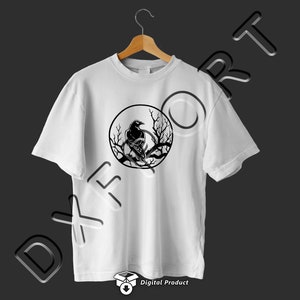 Puede incluir: Camiseta blanca con un gr&aacute;fico en blanco y negro de un cuervo posado en una rama dentro de un c&iacute;rculo.