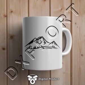 May include: White ceramic mug with a black silhouette of mountains and trees. The mug has a handle and is on a wood background.