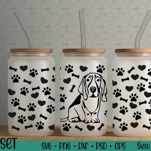 May include: Three clear glass tumblers with black paw prints, hearts, and bones on the outside. Each tumbler has a straw and a wooden lid. The center tumbler has a black silhouette of a Basset Hound dog.