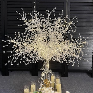 May include: A crystal beaded centerpiece with a silver base and clear lights. The centerpiece is surrounded by candles and a sign that reads "Perfect Party".