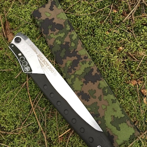 Könnte beinhalten: Eine silberne Faltsäge mit schwarzem Griff und einer Tarnhülle. Die Säge ist mit "Silky Bigboy 360" beschriftet.
