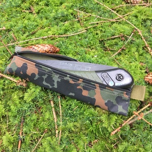 May include: A camouflage fabric saw case with a black folding saw inside. The saw has a green handle and a black blade with the word "Bahco" printed on it.
