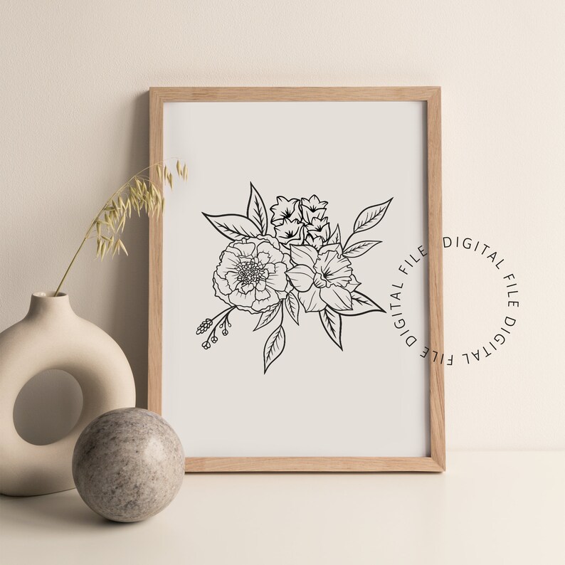 May include: A framed floral line art print featuring a bouquet of flowers in black ink on a cream background. The print is in a light wood frame. A vase and a decorative stone are in the foreground.