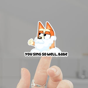 May include: A cartoon dog with a white beard and the text "You sing so well, babe" is on a finger.